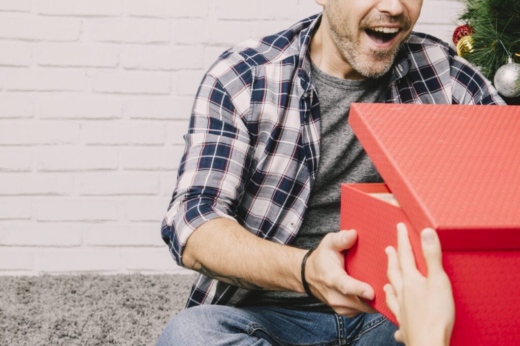 Man die een bierbrouwpakket kerstcadeau voor mannen uitpakt